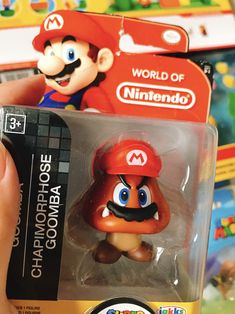 the nintendo world of nintendo super mario figure is being held by someone's hand