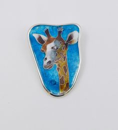 Giraffe - handmade enamel brooch/ pendent is created with ancient technique of cloisonne enamel. (thinnest metal partitions are applied to a metal plate by special glue, are fired in a special kiln for a certain period of time at the temperature of 750 - 900 degrees Celsius. After cooling, the partitions are filled with colors and fired again. Final stage is polishing process). Comes beautifully packed, suitable for gift-giving. Material - Silver, Cloisonne enamel Dimension: 3.7 cm X 5.0 cm Artistic Enamel Brooch Pin For Gift, Silver Enamel Pin For Gift, Handmade Pendant Brooches, Unique Cabochon Brooches As Gift, Unique Handmade Pendant Brooch, Artistic Enamel Pin As A Gift, Artistic Enamel Pin Gift, Artistic Enamel Pin For Gifts, Unique Multicolor Enamel Pin Gift