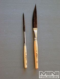 two paint brushes sitting next to each other