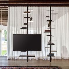 a flat screen tv sitting on top of a wooden shelf