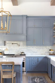 a kitchen with blue cabinets and white counter tops