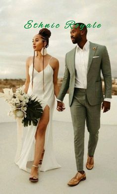 a man and woman are walking down the beach holding each other's hands while wearing white dresses