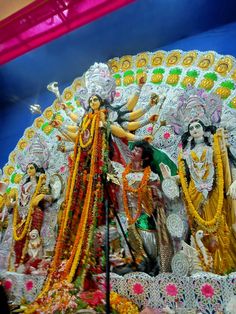 an idol is displayed in front of a blue wall with white and yellow decorations on it