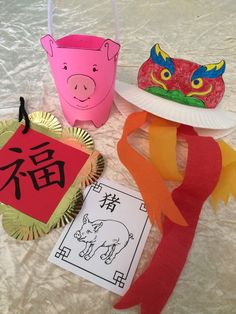 three paper plates with chinese characters on them, one has a pig and the other has a dragon