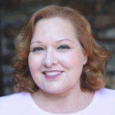 a woman with red hair smiling at the camera