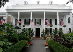 a large white house with american flags on the front