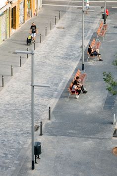 two people sitting on park benches in the middle of an empty lot with no one around them