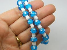 two blue and white beads are being held in someone's hand