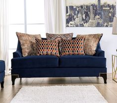 a blue couch sitting in front of a window next to a white rug on top of a hard wood floor