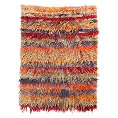 a multicolored rug with fringes on the bottom and sides, against a white background