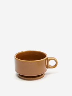 a brown cup sitting on top of a white table