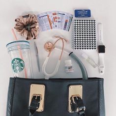 the contents of a purse laid out on top of each other, including a starbucks cup