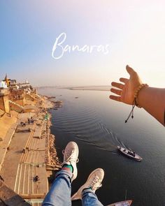 a person is standing on the edge of a cliff with their feet in the air