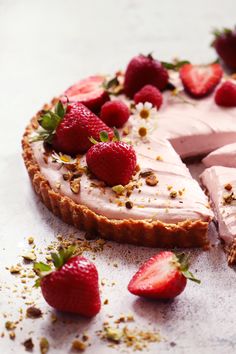 a strawberry cream pie with one slice cut out and some strawberries on the side