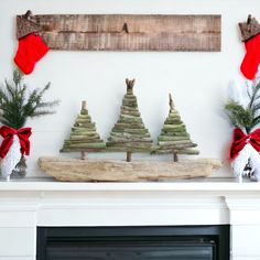 a fireplace mantel decorated with christmas trees and stockings