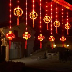 red and white lights hanging from the ceiling in front of a building with decorations on it