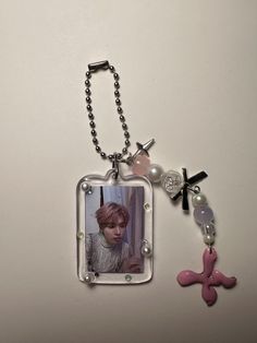 a keychain with an image of a person on it and a cross attached to it