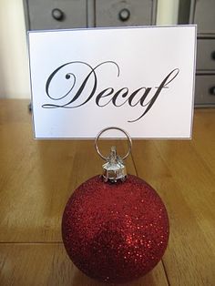 a red ornament sitting on top of a wooden table next to a sign