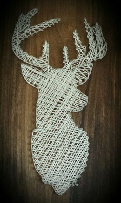 a string art deer head on a wooden surface