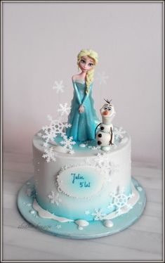 a frozen princess cake with snowflakes on it and a cat sitting on top