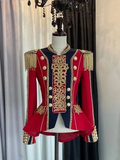 a red and blue uniform on display in front of a window with curtains behind it