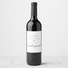 a bottle of wine sitting on top of a marble countertop next to a white wall