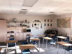 an empty classroom with desks and chairs in front of a map on the wall