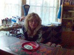 a woman sitting at a table with a red plate on it's counter top