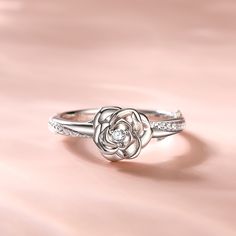 Around the world, the rose is one of the most universal flowers used to express love. This romantic ring poetically evokes a tender promise of love. The rose-inspired stylised bud delicately unfurls its petals, creating the illusion of a real flower. The centre stone sparkles as though bathed in dew.Carat Weight: 0.305 ctStone Size: 1,2 mmStone Type: Jeulia® StoneNumber of Stones: 25 Stone Color: Diamond WhiteStone Shape: RoundWeight: 3 gWidth: 1.9 mmHeight: 5.6 mmThickness: 1.4 mmMaterial: 925 Elegant Rose-colored Flower Ring As Gift, Elegant Rose Flower Ring As Gift, Elegant Rose-colored Flower Ring For Gift, Elegant Rose Colored Flower Ring As Gift, Elegant Rose Flower Ring For Gift, Elegant Flower Rings For Valentine's Day, Rose Design Flower Promise Ring, Elegant Silver Rings With Rose Design, Delicate Rose Design Rose Colored Ring