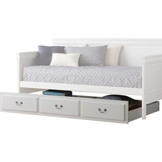 a white daybed with drawers underneath it and pillows on the bottom shelf next to it