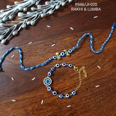 a blue and gold beaded bracelet on a wooden table next to silver beads, sprinkles and flowers