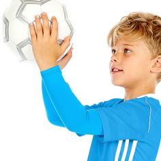 a young boy holding up a soccer ball