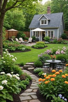 a garden with lots of flowers and plants around the house, including an outdoor dining area