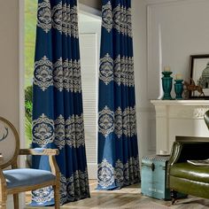 a living room filled with furniture and a window covered in blue drapes next to a fire place