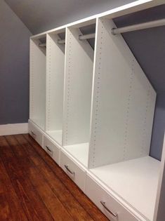 an empty room with white closets and drawers on the floor in front of a gray wall