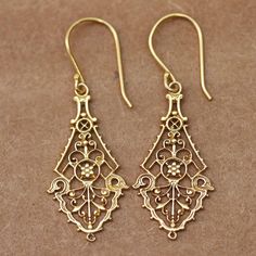 Tradition and love for India's culture create a refined pair of 22k gold-plated dangle earrings featuring filigree motifs around their structure. Indian artisan Bhavya Jain handcrafts the accessory following classic themes, enhancing the pieces with a high polish finish for extra glamour. Ornate Historical Design Earrings, Formal Filigree Baroque Earrings, Formal Baroque Filigree Earrings, Elegant Yellow Gold Earrings With Historical Design, Ornate Gold Earrings With Historical Design, Gold Earrings With Historical Design For Formal Occasions, Ceremonial Elegant Chandelier Earrings With Intricate Design, Elegant Ceremonial Chandelier Earrings With Intricate Design, Antique Gold Earrings With Historical Design