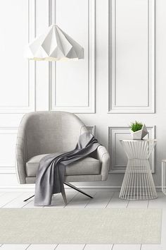 a chair and table in a room with white paneled walls, flooring and artwork