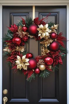 a christmas wreath with poinsettis and bells hanging on a front door decorated for the holiday season