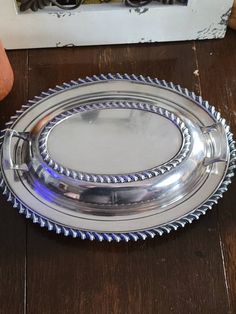 a silver plate sitting on top of a wooden table