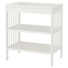 a white baby crib with two shelves on the bottom and one shelf below it