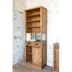 a wooden bookcase with two drawers and one door on the front, against a white wall