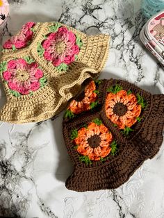 two crocheted purses sitting on top of a marble counter next to each other