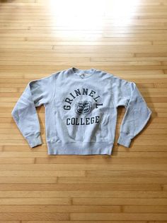 Up for sale is a vintage 1990's Champion heavy reverse weave sweatshirt in size small advertising Grinnell College. Overall the sweatshirt is in great shape though it does have two areas of staining / discoloration, including some faded yellow on a sleeve cuff and some faded pink areas on the bottom front of the garment (see photos). No major rips or tears were noted. Other wear consistent with age may be present, such as pilling or pulled threads. Champion Reverse Weave  Size Small Measured flat: 21 ½ inches pit to pit 18 inches shoulder to shoulder 27 inches cuff to shoulder 24 inches long back bottom of collar to bottom of garment 3 Grinnell College, Fringe Coats, 80s Mens, Streetwear Sweatshirt, University Sweatshirts, College Sweatshirt, Grey Crewneck, Champion Reverse Weave, Vintage Champion