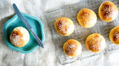 small buns on a cooling rack with a blue plate and knife next to them