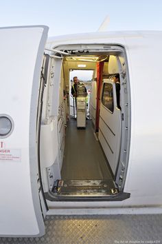 an airplane with the door open and two men standing inside