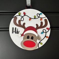 a christmas ornament hanging on a door with lights and reindeer's head