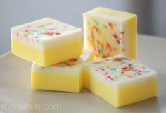 three pieces of yellow soap with sprinkles on them sitting on a white plate