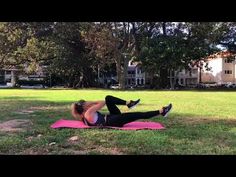 a woman laying on top of a pink mat in the grass