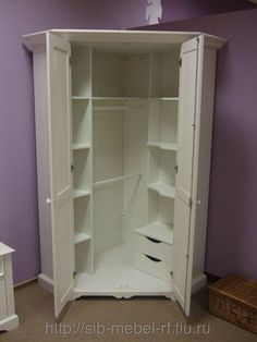 an empty white wardrobe in a room with purple walls and drawers on the bottom shelf