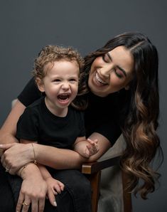 a woman sitting next to a child smiling